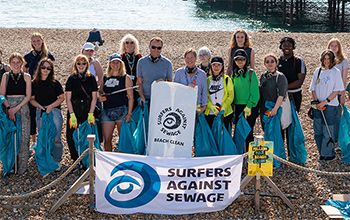 Students and staff pose for a group photo on Brighton beach, after completing a beach clean with Surfers Against Sewage.
